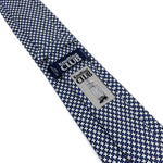the back side of a Blue and White Houndstooth silk tie showing the company logo and tag