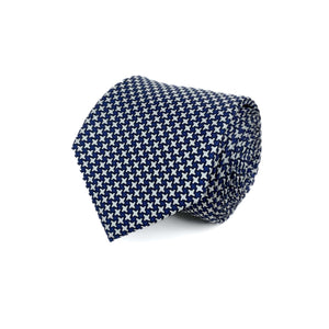Blue and White Houndstooth silk tie rolled and placed on a white background