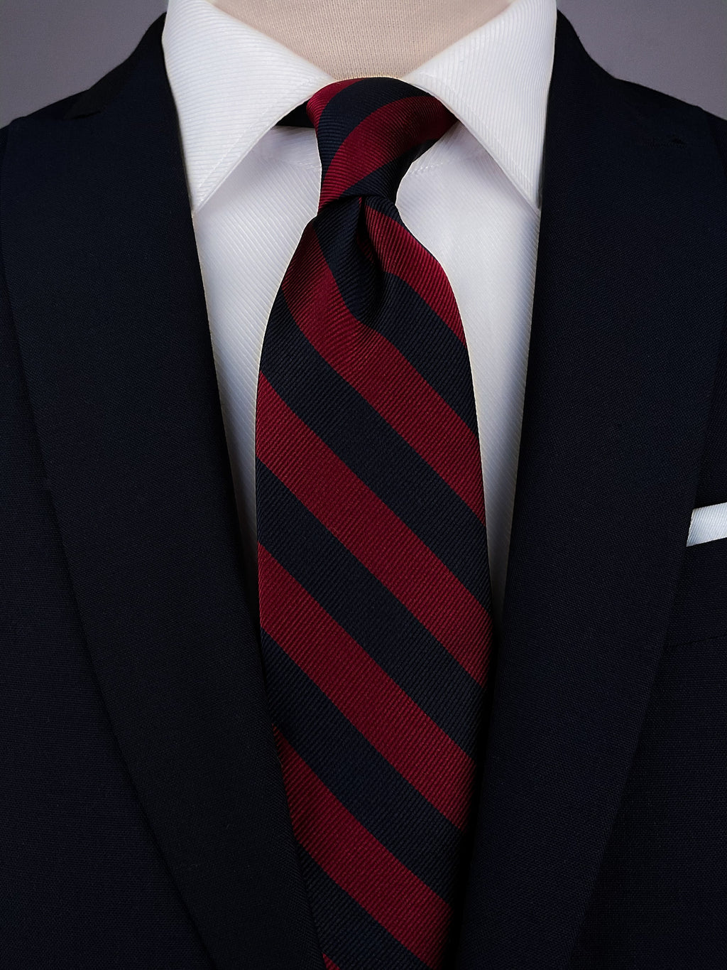 Red and Navy Blue Striped Silk Regimental tie worn with a white shirt and a navy blue suit