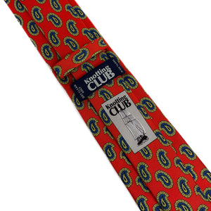 Orange-red silk twill tie with a green and blue paisley pattern shown from the back with the label and company logo visible.
