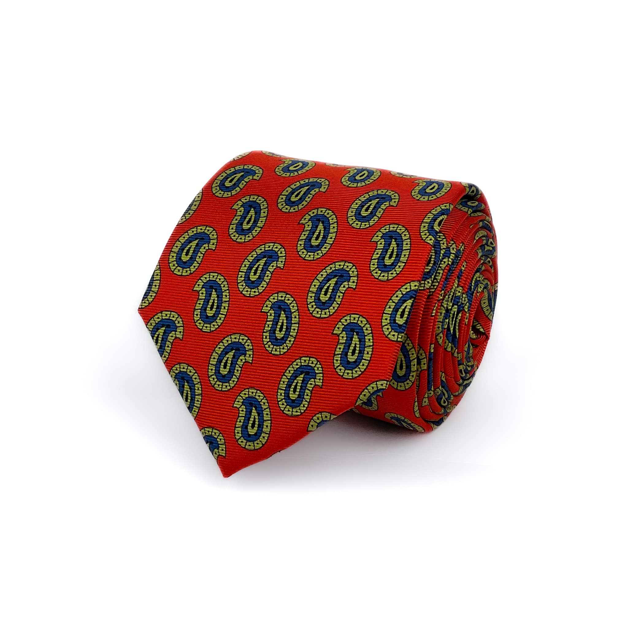 Orange-red silk twill tie with a green and blue paisley pattern rolled and placed against a white background