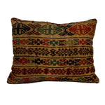 An antique kilim rug cushion with a multicolored geometric print placed on a white background.