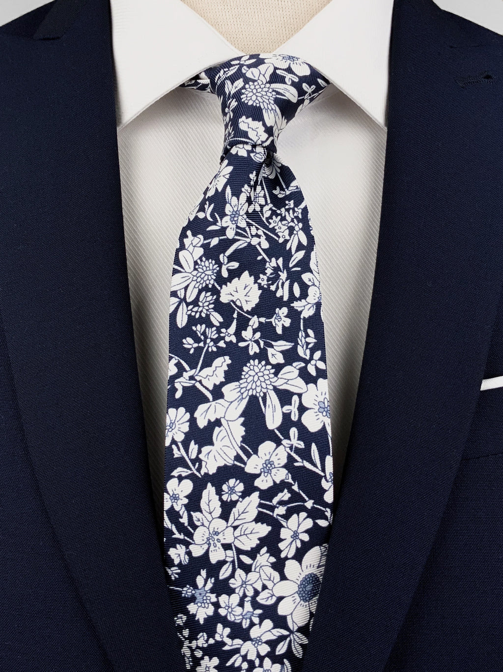Navy blue mulberry silk twill tie with a white floral print worn with a white shirt and a navy blue suit