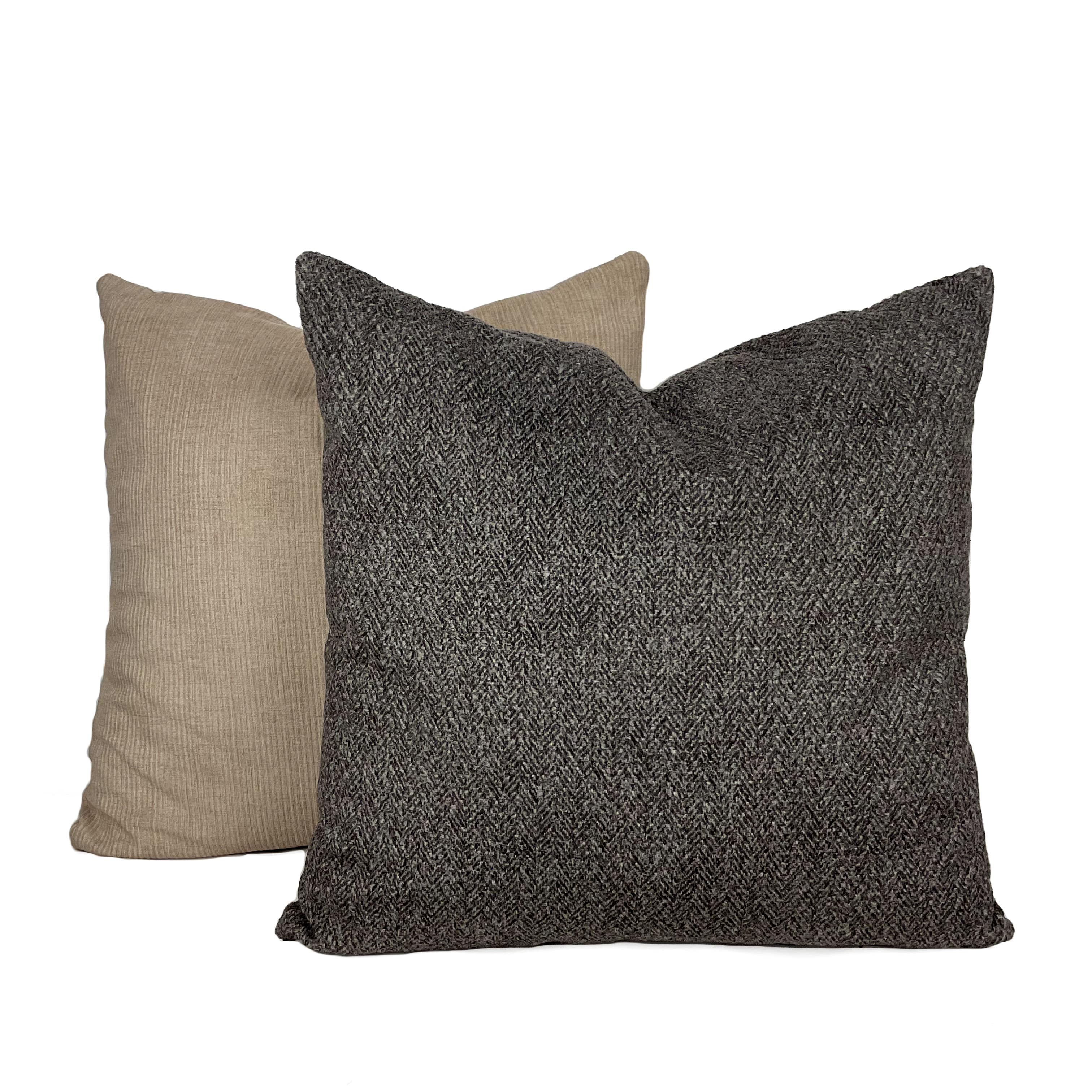 A slate grey plain suede cushion placed against a white background