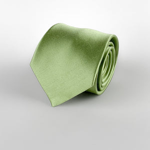 spring green mulberry silk satin tie rolled and placed on a white background