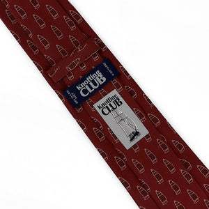 the back side of a burgundy red tie with a pattern of ships printed on it. The label and logo of the brand is showing on the back side of the tie.