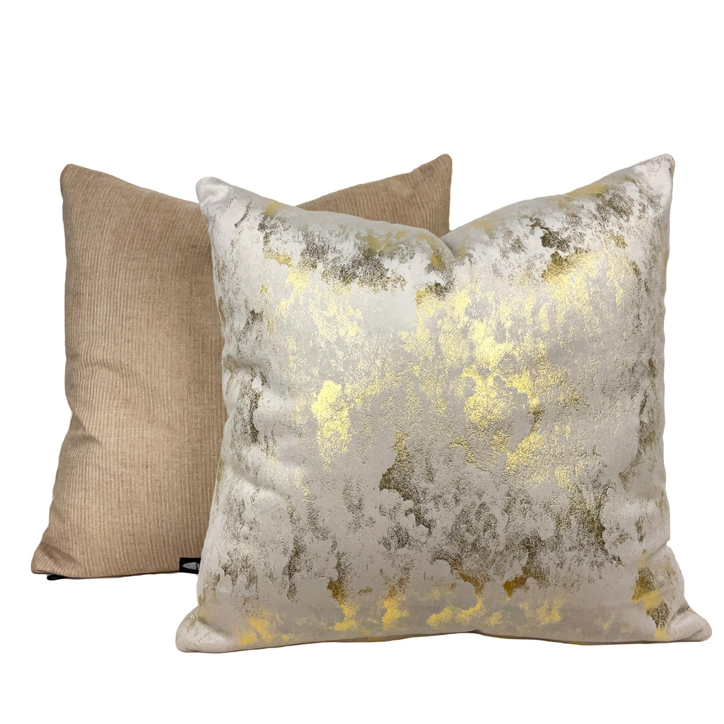 Cream white suede cushion with delicate gold detailing placed on a white background