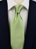Spring green mulberry silk satin tie worn with a white shirt and a navy suit