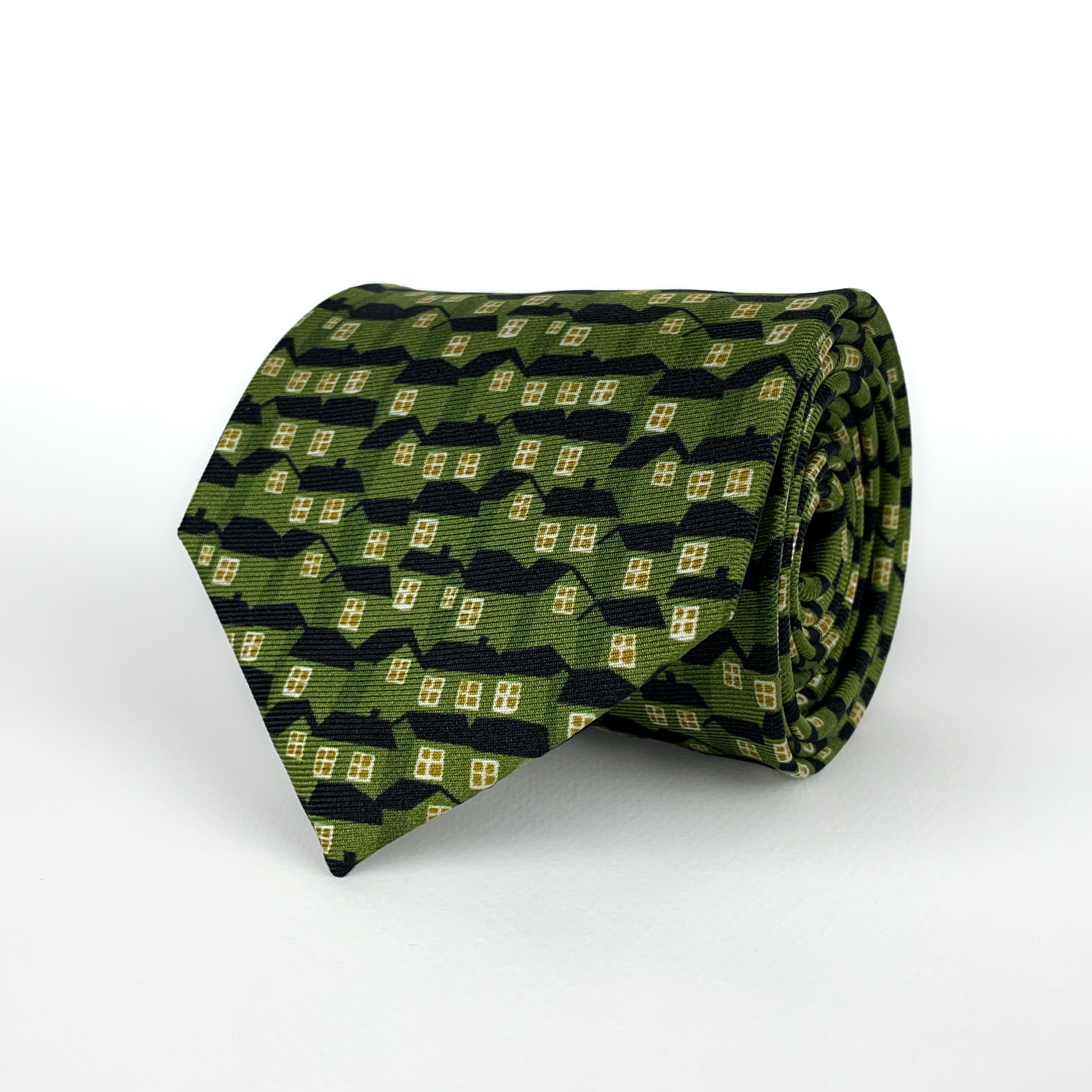 Mulberry silk twill tie printed with a pattern of houses in a green color with black roofs and yellow windows rolled and placed on a white background