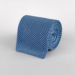 Sky blue mulberry silk knitted tie with a square end rolled and placed on a white background