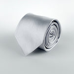 steel grey mulberry silk satin tie rolled and placed on a white background
