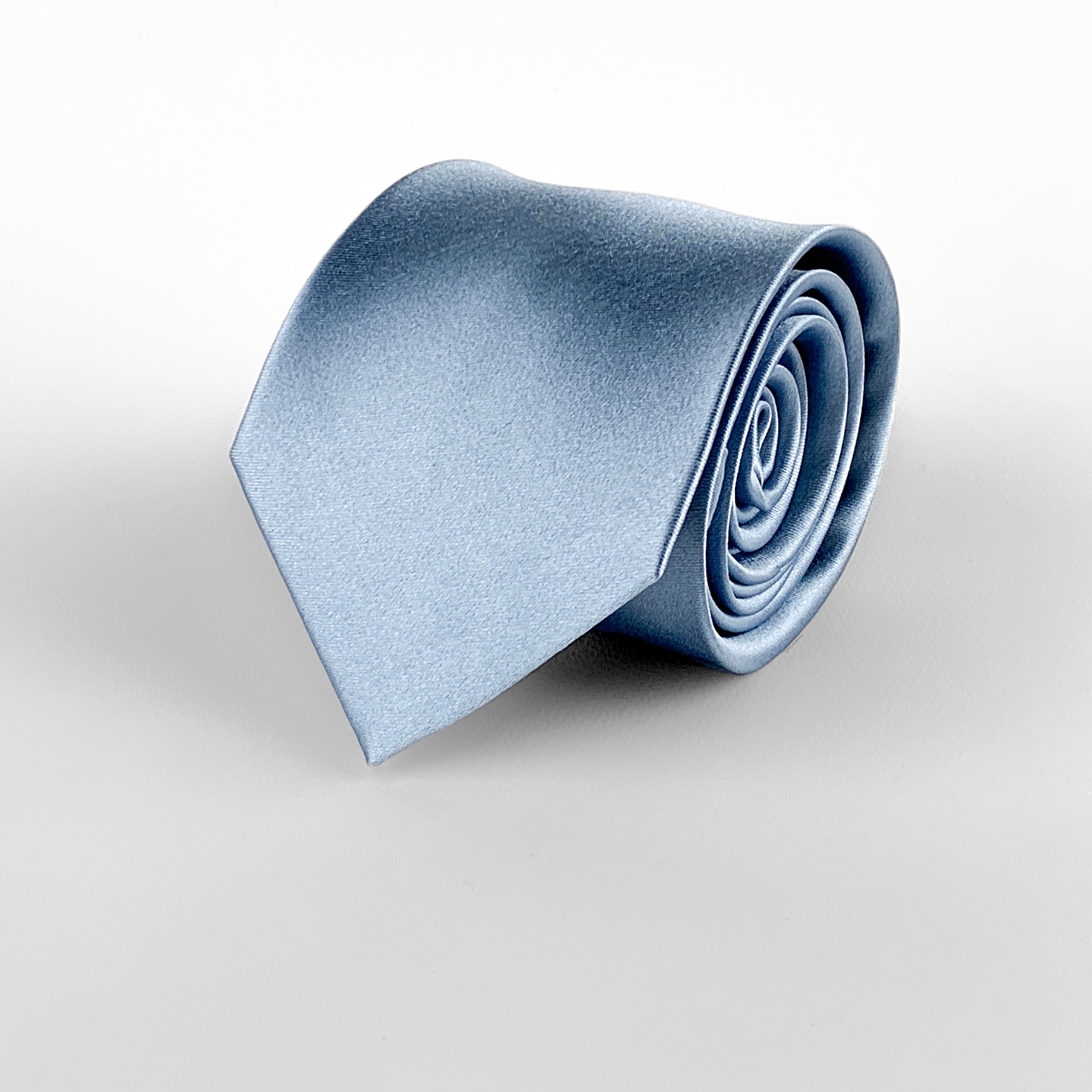 Ice blue mulberry silk satin tie rolled and placed on a white background