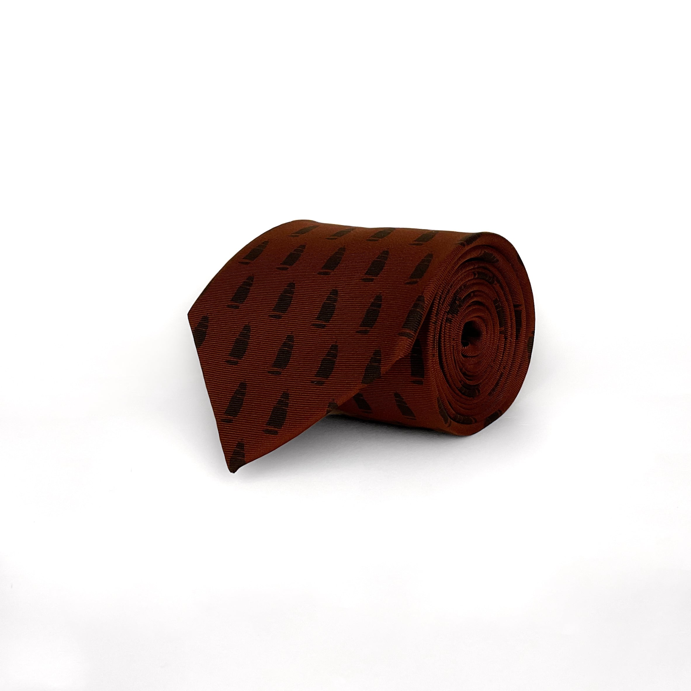Burgundy red silk tie with a printed pattern of ships.  The tie is rolled and placed on a white background