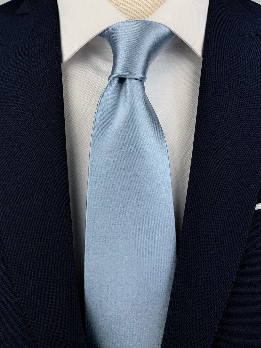 Ice blue mulberry silk satin tie on a white shirt and a navy blue suit