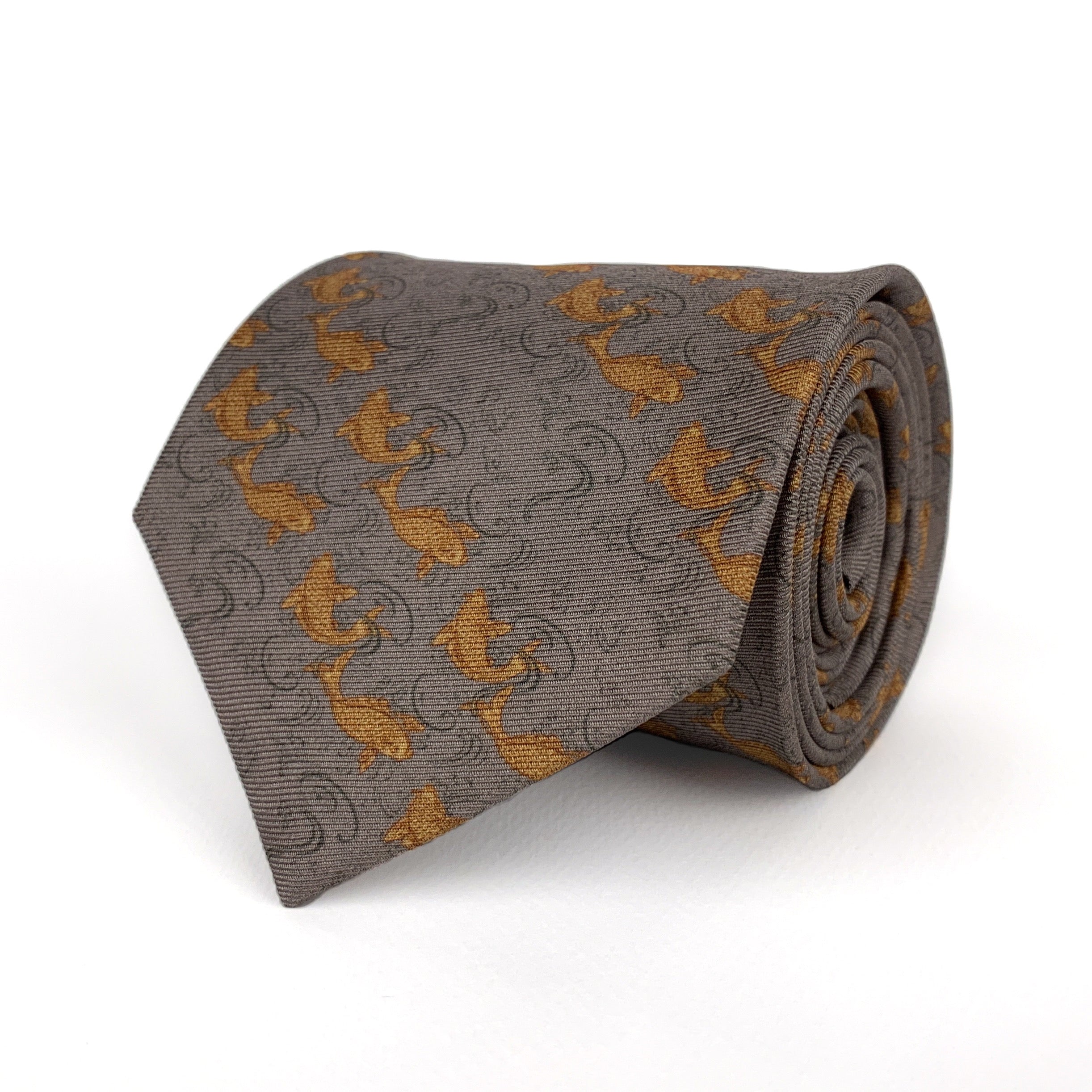 Mulberry silk twill tie in a grey color with a printed pattern of orange fish placed in diagonal stripes rolled and placed on a white background
