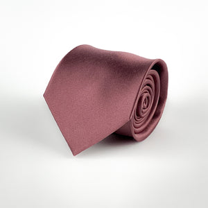 Dark mauve pink silk satin tie rolled and placed on a white background