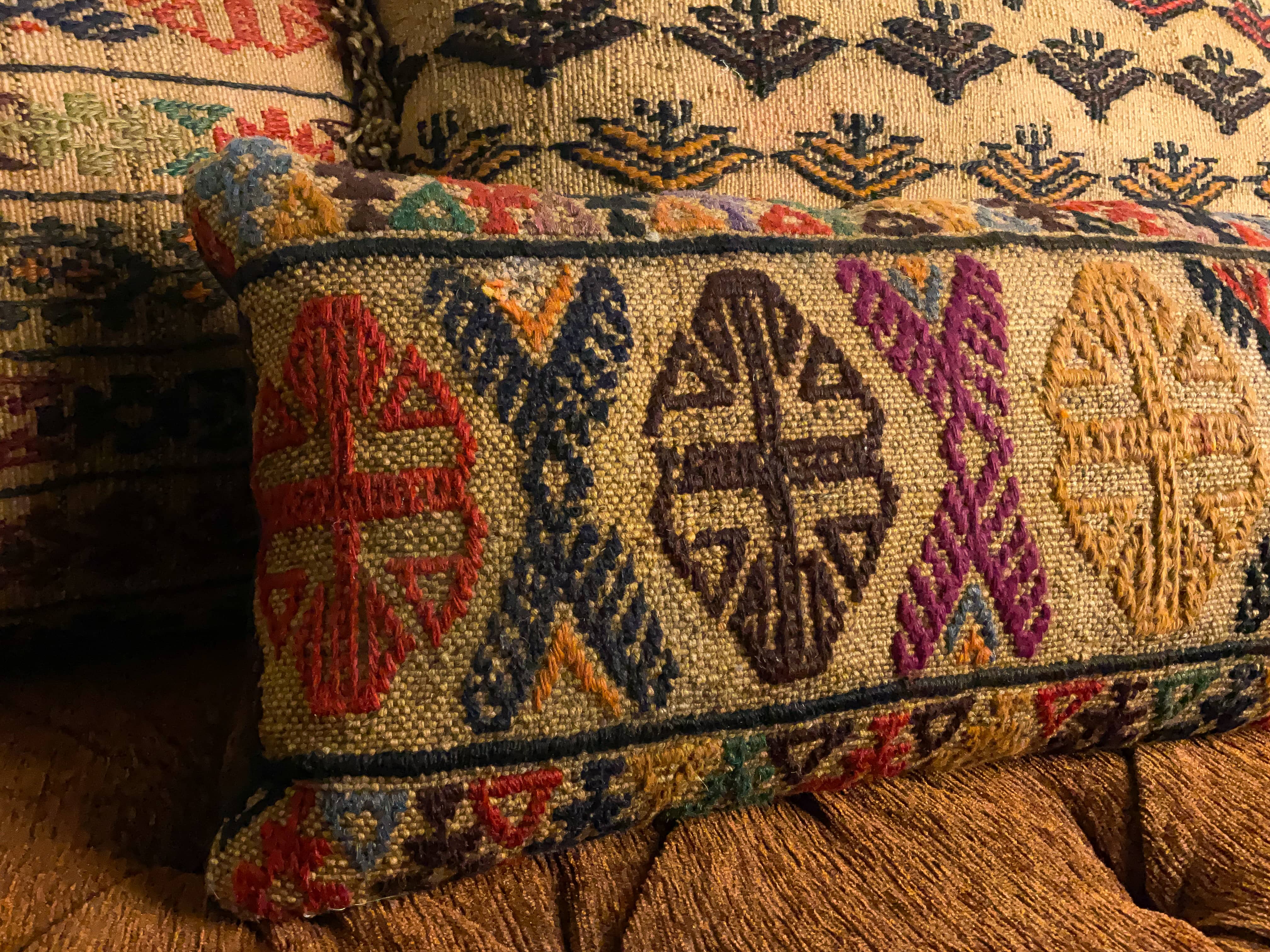 Multiple antique kilim rug cushions placed on a bench