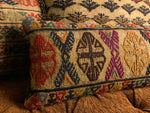 Multiple antique kilim rug cushions placed on a bench