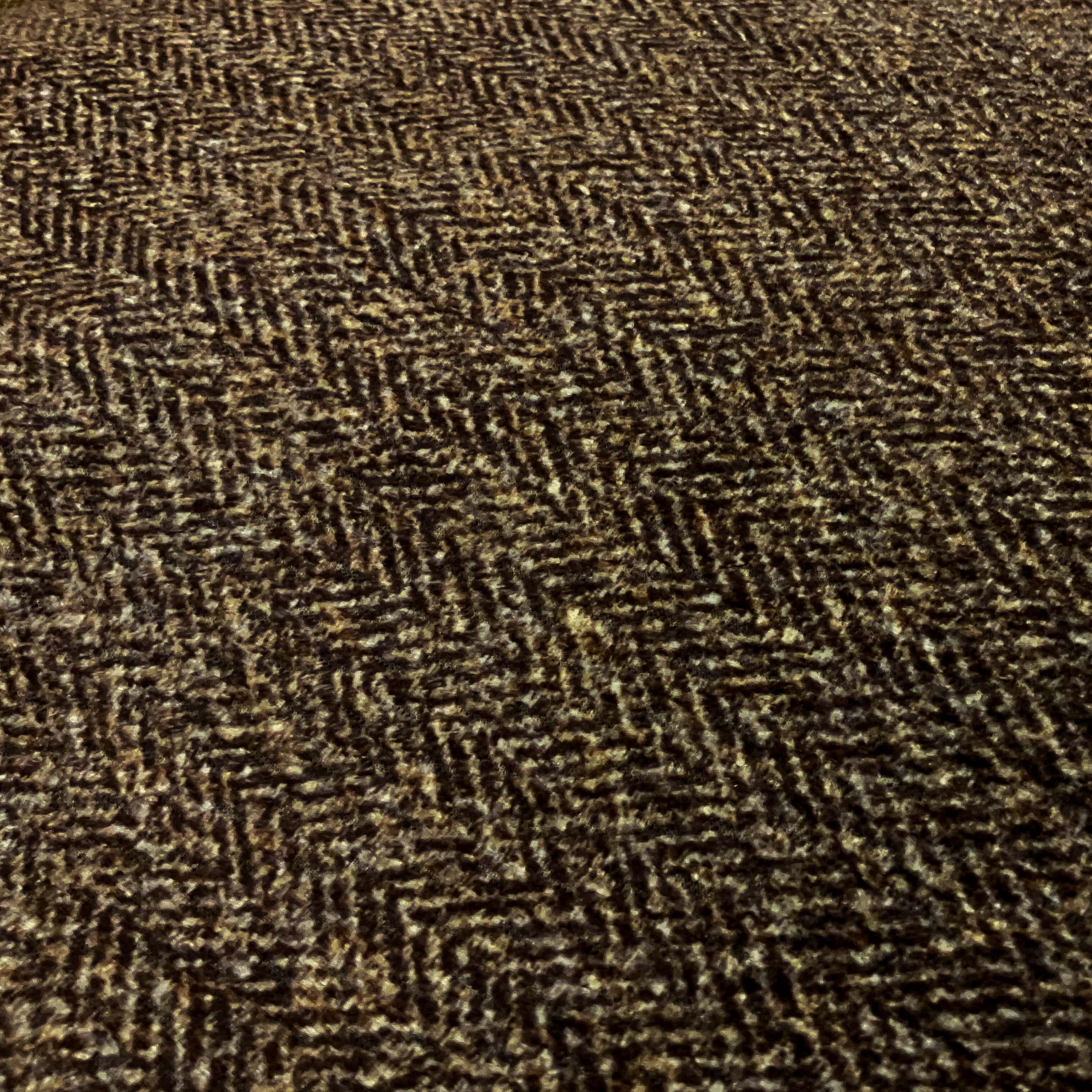 fabric closeup of a plain brown suede cushion showing a geometric pattern