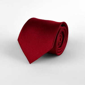 Dark red mulberry silk satin tie rolled and placed on a white background