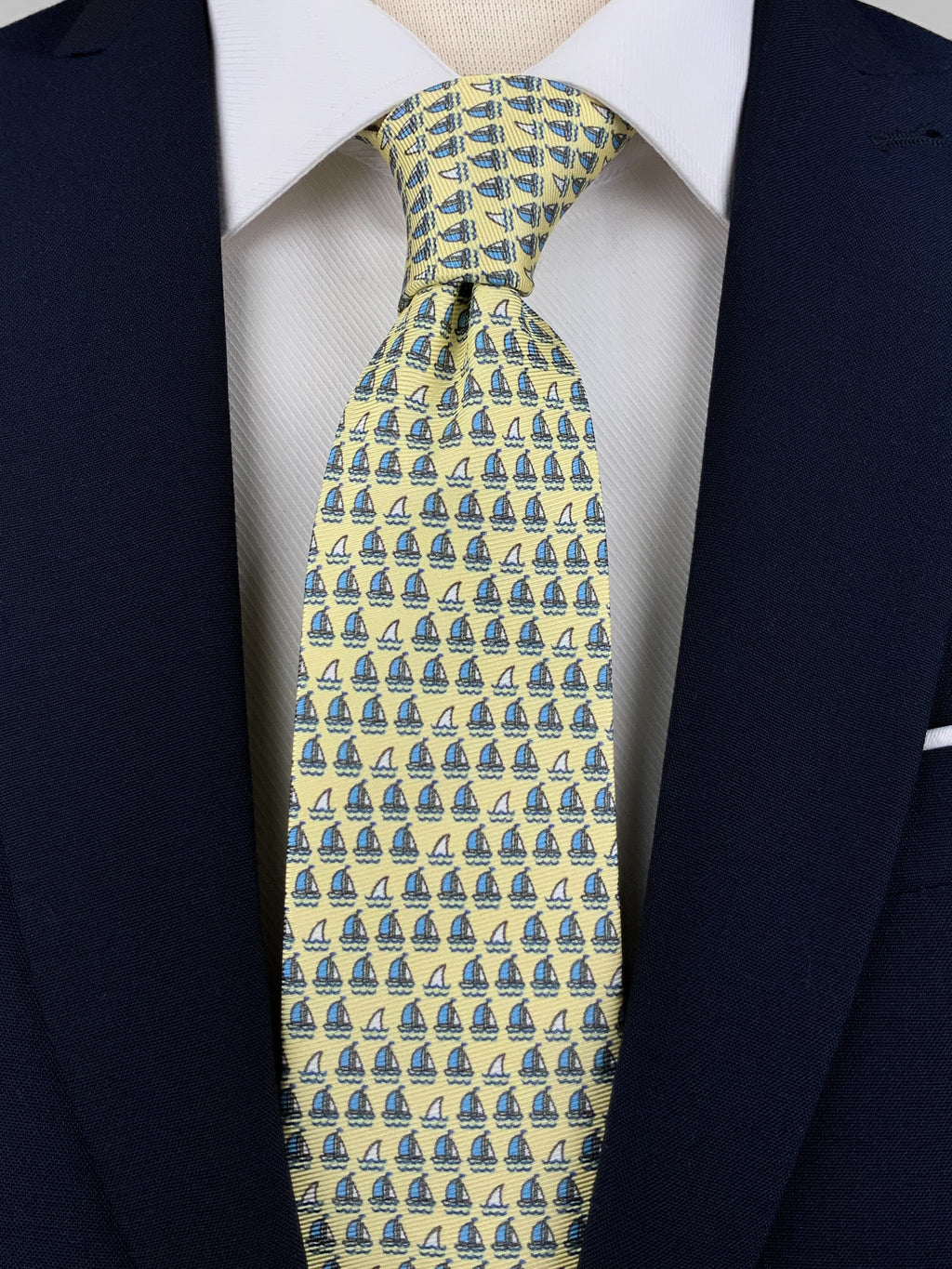 Mulberry silk twill tie in a lime yellow color with a blue microprint of ships and fish worn with a white shirt and a navy blue suit