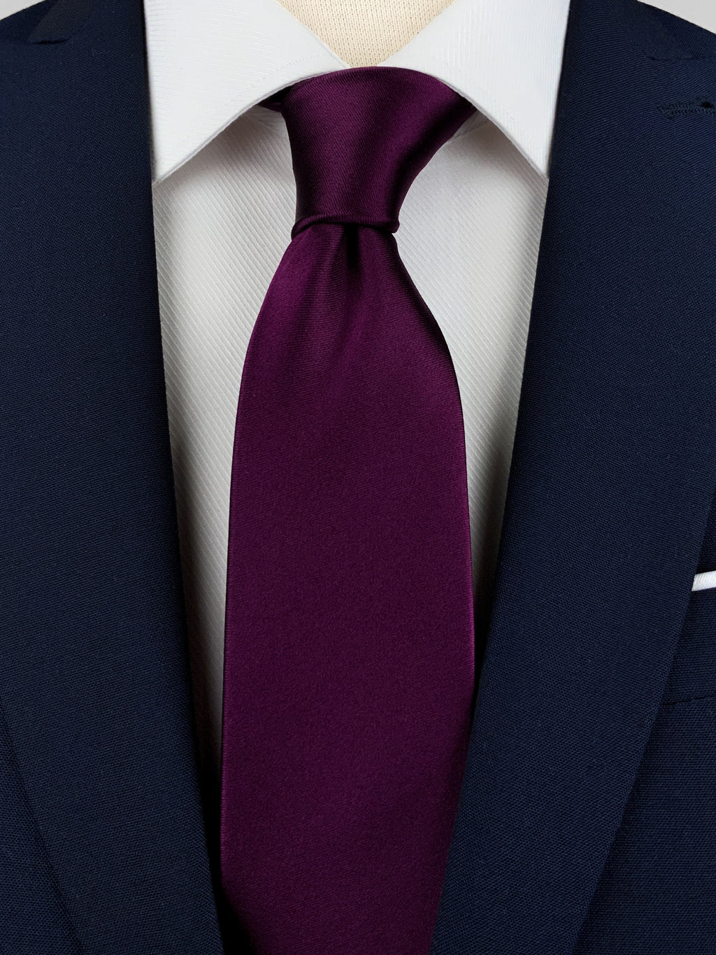 Dark purple mulberry silk satin tie worn with a white shirt and a navy blue suit