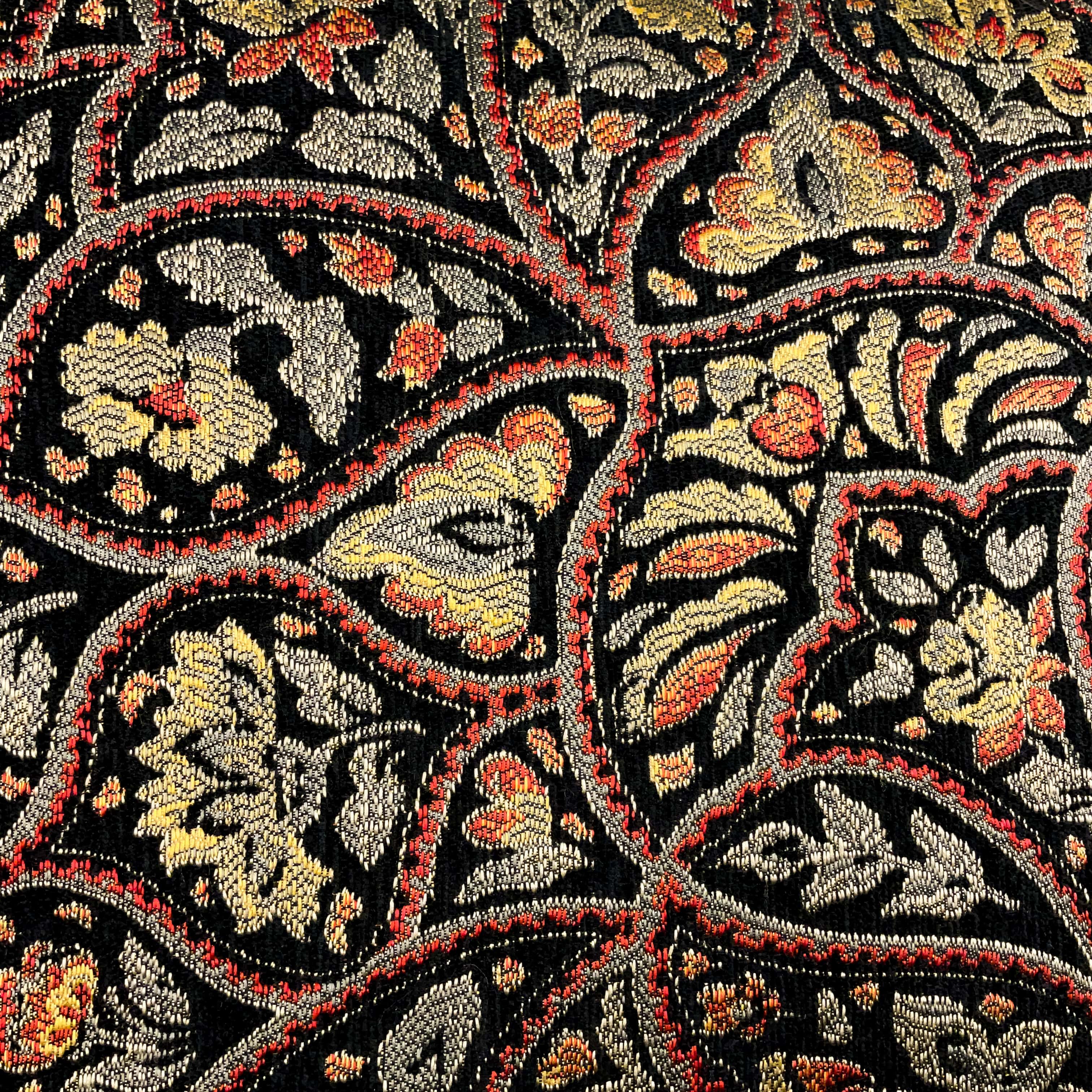 Fabric of a black floral embroidered cushion.