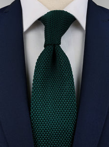 dark emerald green silk knitted tie worn with a white shirt and a navy blue suit