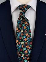 Mulberry silk twill tie with a multi-colored rainforest floral print on a black base worn with a white shirt and a navy blue suit