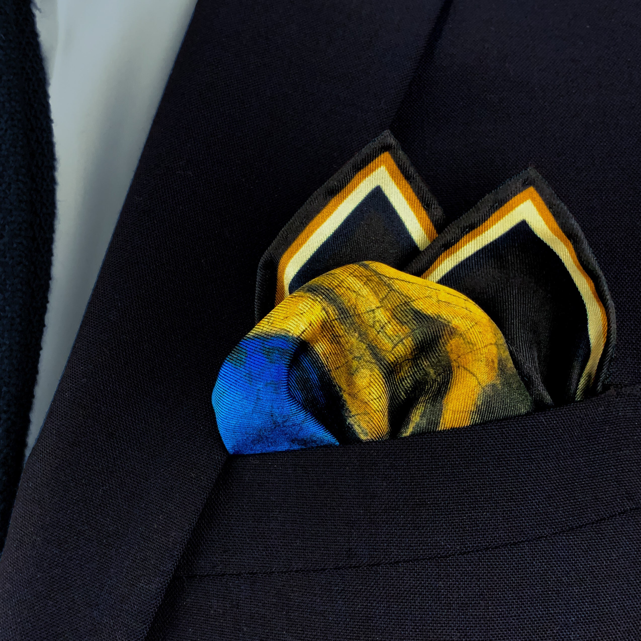 Girl with a pearl earring historical art silk pocket square folded and placed in the breast pocket of a navy blue suit.