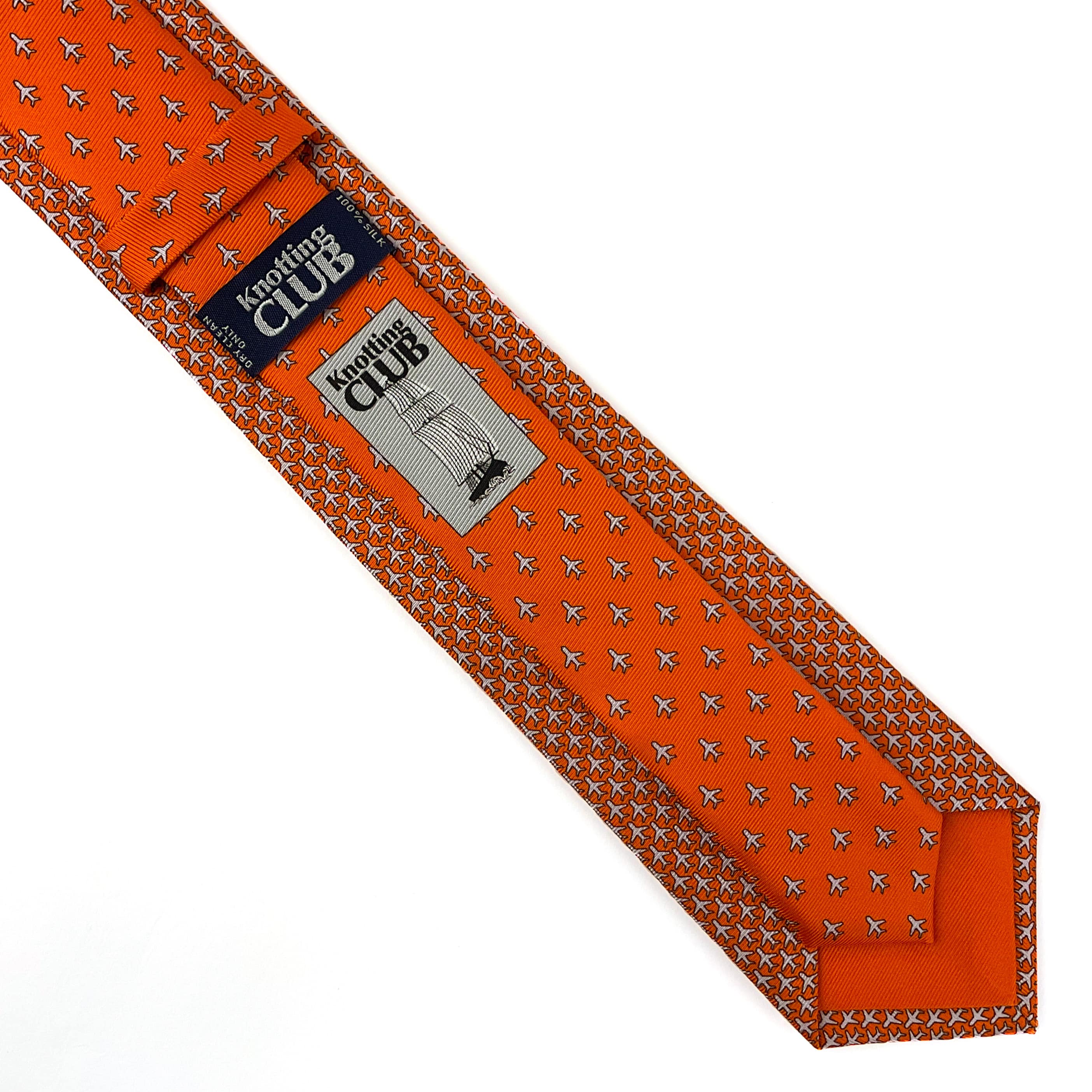 Orange 100% mulberry silk twill necktie with a microprint of airplanes and a bright orange tail placed on a white background